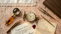 Übersichtsaufnahme einer Werkstatt-Restaurations-Szene, restaurierte italienische Taschenuhr, Messing-Lupe, Pinzetten, Restaurations-Urkunde mit rotem Siegel